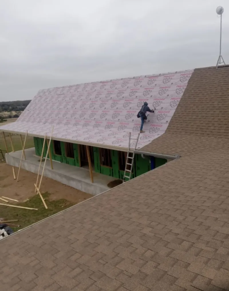 Worker preparing underlayment for a metal roof installation in Ceres